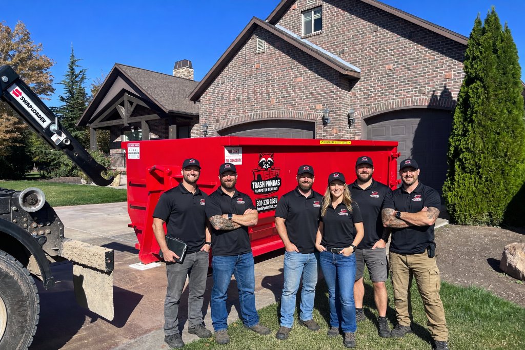 The Trash Pandas Utah crew with a roll-off truck and dumpster